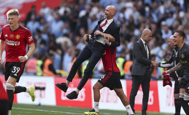 FILE - Manchester United's Lisandro Martinez lifts Manchester United's head coach Erik ten Hag while celebrating victory in the English FA Cup final soccer match between Manchester City and Manchester United at Wembley Stadium in London, Saturday, May 25, 2024. (AP Photo/Ian Walton, File)