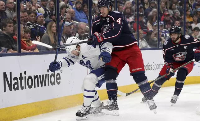 Columbus Blue Jackets forward Cole Sillinger, right, reaches for the puck behind Toronto Maple Leafs defenseman Morgan Rielly during the second period of an NHL hockey game in Columbus, Ohio, Tuesday, Oct. 22, 2024. (AP Photo/Paul Vernon)