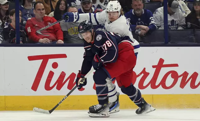 Columbus Blue Jackets defenseman Damon Severson, left, blocks Toronto Maple Leafs forward Bobby McMann from the puck during the first period of an NHL hockey game in Columbus, Ohio, Tuesday, Oct. 22, 2024. (AP Photo/Paul Vernon)