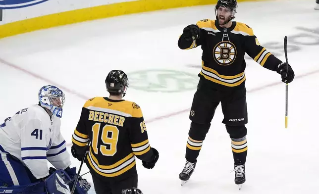 Boston Bruins' Mark Kastelic (47) celebrates his goal on Toronto Maple Leafs' Anthony Stolarz (41) with teammate John Beecher (19) during the second period of an NHL hockey game, Saturday, Oct. 26, 2024, in Boston. (AP Photo/Michael Dwyer)