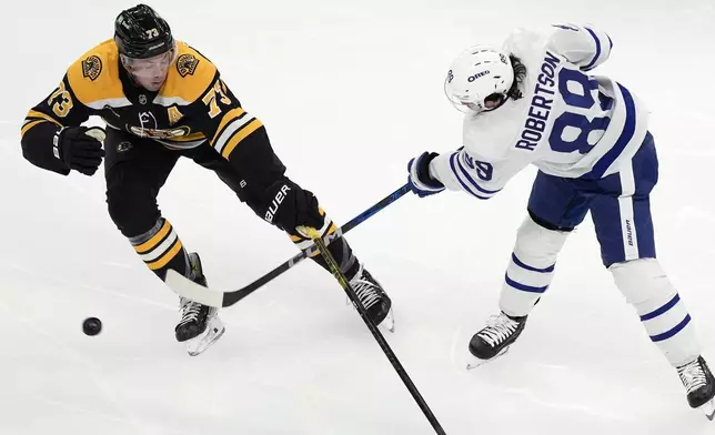 Boston Bruins' Charlie McAvoy (73) defends against Toronto Maple Leafs' Nicholas Robertson (89) during the first period of an NHL hockey game, Saturday, Oct. 26, 2024, in Boston. (AP Photo/Michael Dwyer)