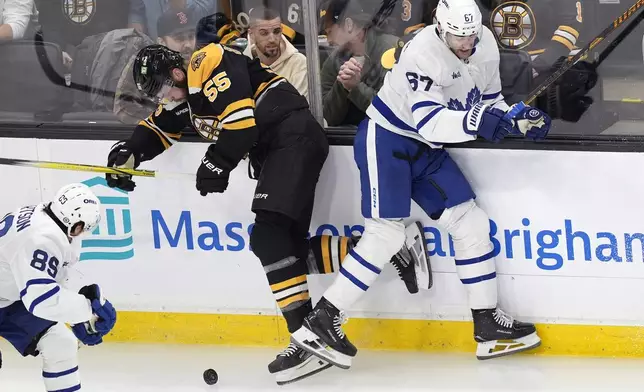 Boston Bruins' Justin Brazeau (55) battles Toronto Maple Leafs' Max Pacioretty (67) for the puck during the first period of an NHL hockey game, Saturday, Oct. 26, 2024, in Boston. (AP Photo/Michael Dwyer)