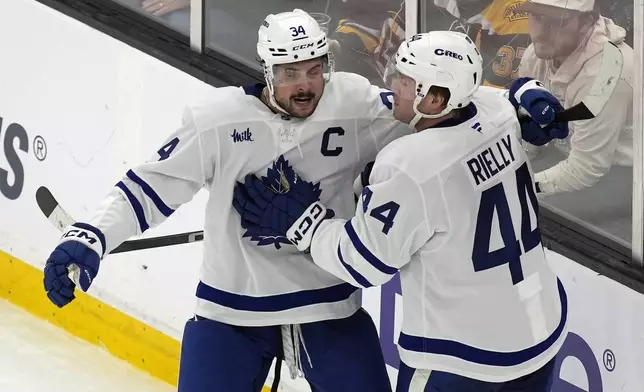 Toronto Maple Leafs' Morgan Rielly (44) celebrates his goal with Auston Matthews (34) during the second period of an NHL hockey game against the Boston Bruins, Saturday, Oct. 26, 2024, in Boston. (AP Photo/Michael Dwyer)