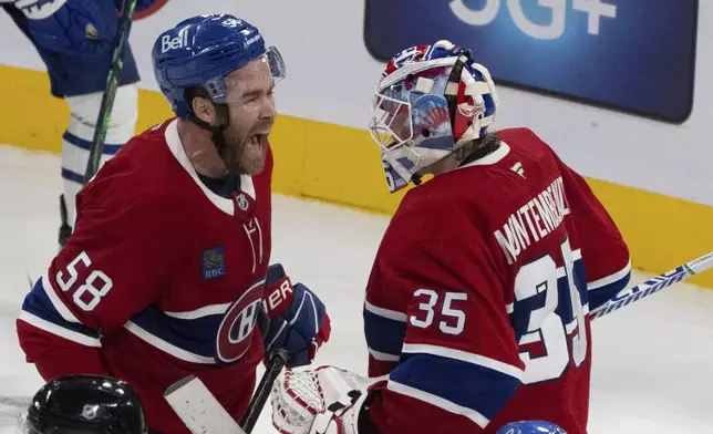 Montreal Canadiens' David Savard (58) celebrates their win with goaltender Sam Montembeault (35) following an NHL hockey game against the Toronto Maple Leafs, Wednesday, Oct. 9, 2024 in Montreal. (Christinne Muschi/Canadian Press via AP)