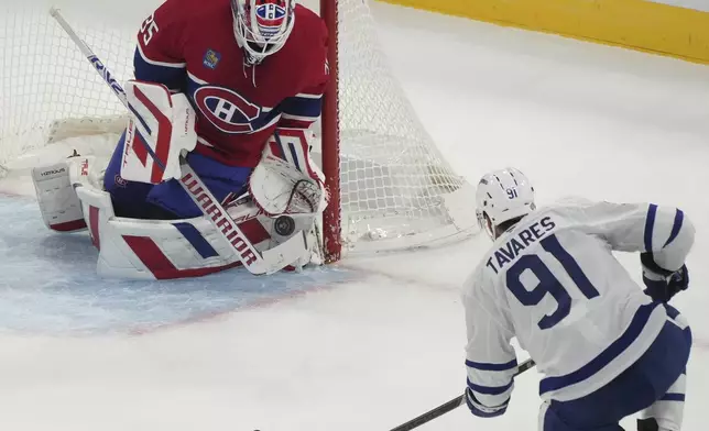 Montreal Canadiens goaltender Sam Montembeault (35) stops a shot by Toronto Maple Leafs' John Tavares (91) during the first period of an NHL hockey game, Wednesday, Oct. 9, 2024 in Montreal. (Christinne Muschi/Canadian Press via AP)