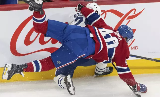 Montreal Canadiens' Joel Armia (40) is upended on the boards with Toronto Maple Leafs' Pontus Holmberg (29) during the second period of an NHL hockey game in Montreal, Wednesday, Oct. 9, 2024. (Christinne Muschi/The Canadian Press via AP)