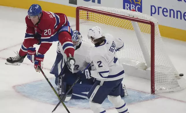 Montreal Canadiens' Juraj Slafkovsky (20) tries to screen a shot on Toronto Maple Leafs goaltender Anthony Stolarz (41) as Leafs' Simon Benoit (2) defends during the second period of a NHL hockey game in Montreal, Wednesday, Oct. 9, 2024. (Christinne Muschi/The Canadian Press via AP)