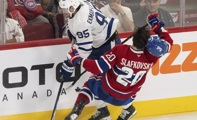 Montreal Canadiens' Juraj Slafkovsky (20) is checked by Toronto Maple Leafs' Oliver Ekman-Larsson (95) during the third period of an NHL hockey game, Wednesday, Oct. 9, 2024 in Montreal. (Christinne Muschi/Canadian Press via AP)