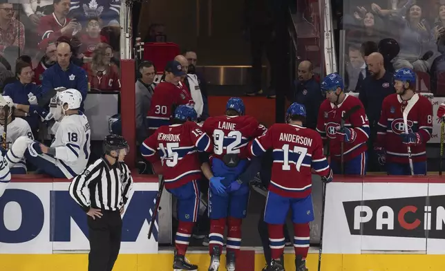 Montreal Canadiens' Patrik Laine (92) is helped off the ice by teammates following a collision with a Toronto Maple Leas player during first period NHL preseason game in Montreal on Saturday, Sept. 28, 2024. (Evan Buhler/The Canadian Press via AP)