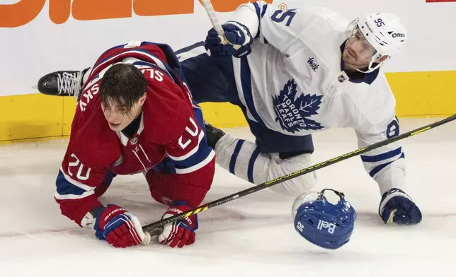 Montreal Canadiens' Juraj Slafkovsky (20) is checked by Toronto Maple Leafs' Oliver Ekman-Larsson (95) during the third period of an NHL hockey game, Wednesday, Oct. 9, 2024 in Montreal. (Christinne Muschi/Canadian Press via AP)