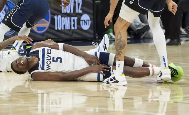 Minnesota Timberwolves guard Anthony Edwards (5) lays on the ground after falling during the second half of an NBA basketball game against the Dallas Mavericks, Tuesday, Oct. 29, 2024, in Minneapolis. (AP Photo/Abbie Parr)