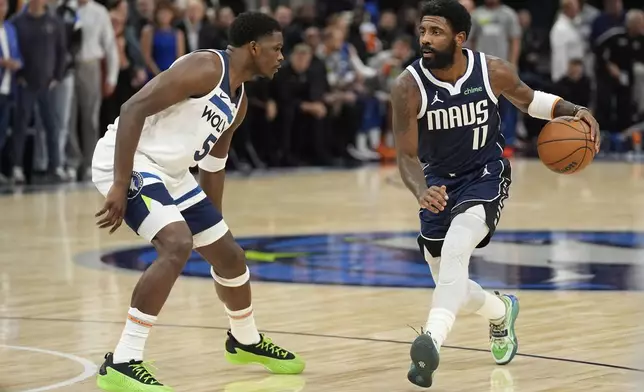 Dallas Mavericks guard Kyrie Irving (11) works toward the basket as Minnesota Timberwolves guard Anthony Edwards (5) defends during the first half of an NBA basketball game, Tuesday, Oct. 29, 2024, in Minneapolis. (AP Photo/Abbie Parr)