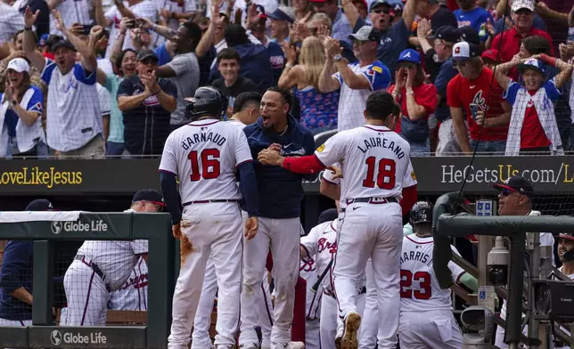 Atlanta Braves' Travis d'Arnaud, left, Orlando Arcia, center, and Ramón Laureano, right, celebrate after scoring in the eighth inning of a baseball game against the New York Mets, Monday, Sept. 30, 2024, in Atlanta. (AP Photo/Jason Allen)