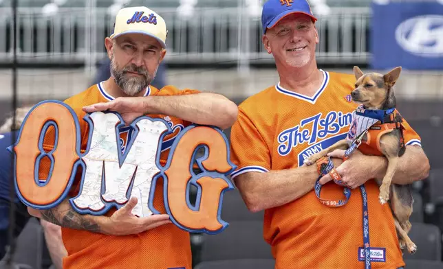 New York Mets fans await their turn to get autographs before the start of a baseball game against the Atlanta Braves, Monday, Sept. 30, 2024, in Atlanta. (AP Photo/Jason Allen)