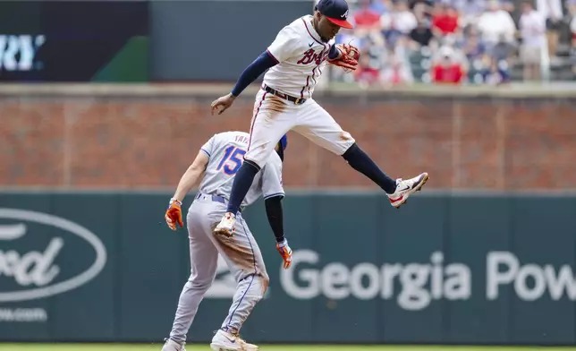 New York Mets' Tyrone Taylor steal second base before Atlanta Braves second baseman Ozzie Albies, top, can tag him in the third inning of a baseball game, Monday, Sept. 30, 2024, in Atlanta. (AP Photo/Jason Allen)