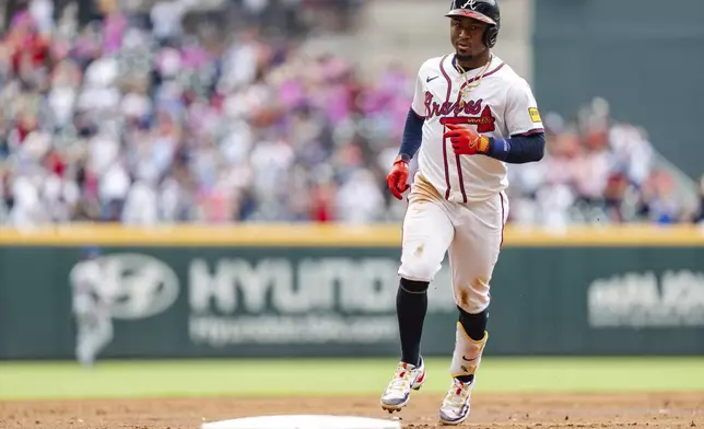 Atlanta Braves' Ozzie Albies prepares to tag third base after hitting a two-run home run in the third inning of a baseball game against the New York Mets, Monday, Sept. 30, 2024, in Atlanta. (AP Photo/Jason Allen)