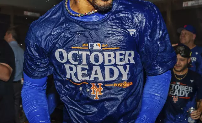 New York Mets shortstop Francisco Lindor celebrates in the locker room after clinching a playoff berth with a victory in the first baseball game of a doubleheader against the Atlanta Braves, Monday, Sept. 30, 2024, in Atlanta. (AP Photo/Jason Allen)