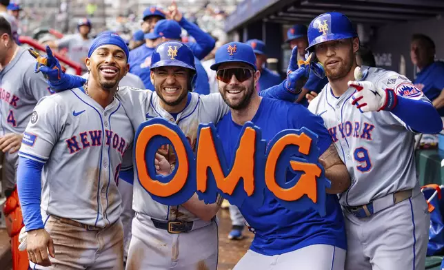 New York Mets' Francisco Lindor, left, Jose Iglesias, left center, David Peterson, right center, and Brandon Nimmo, right, celebrate in the dugout after taking the lead in the eighth inning of a baseball game against the Atlanta Braves, Monday, Sept. 30, 2024, in Atlanta. (AP Photo/Jason Allen)