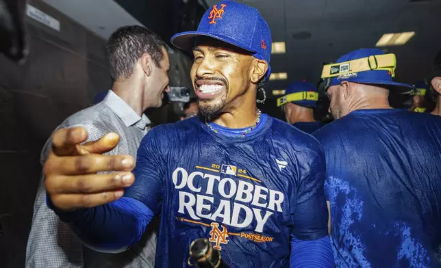 New York Mets shortstop Francisco Lindor celebrates in the locker room after clinching a playoff berth with a victory in the first game of a doubleheader against the Atlanta Braves, Monday, Sept. 30, 2024, in Atlanta. (AP Photo/Jason Allen)