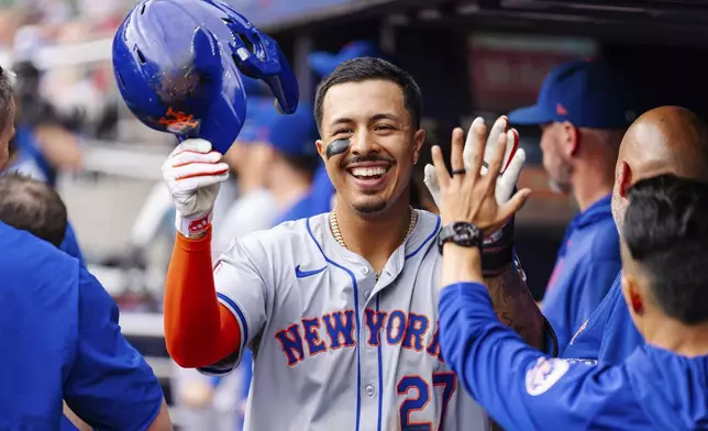 New York Mets' Mark Vientos celebrates in the dugout after scoring in the eighth inning of a baseball game against the Atlanta Braves, Monday, Sept. 30, 2024, in Atlanta. (AP Photo/Jason Allen)