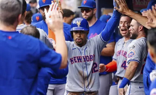 New York Mets' Francisco Lindor celebrates in the dugout after scoring in the eighth inning of a baseball game against the Atlanta Braves, Monday, Sept. 30, 2024, in Atlanta. (AP Photo/Jason Allen)