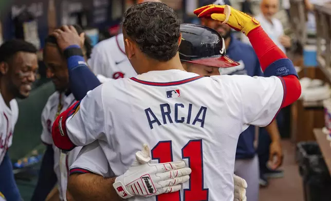 Atlanta Braves' Ramon Laureano, behind, celebrates with Atlanta Braves Orlando Arcia, front, in the dugout after hitting a solo home run to centerfield in the sixth inning of a baseball game against the New York Mets, Monday, Sept. 30, 2024, in Atlanta. (AP Photo/Jason Allen)