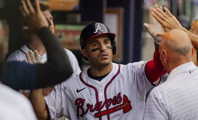 Atlanta Braves' Ramon Laureano, center, celebrates with teammates in the dugout after hitting a solo home run to centerfield in the sixth inning of a baseball game against the New York Mets, Monday, Sept. 30, 2024, in Atlanta. (AP Photo/Jason Allen)