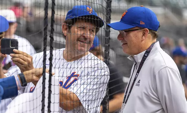 New York Mets owner Steve Cohen, right, poses with a fan for a photo before the start of a baseball game against the Atlanta Braves, Monday, Sept. 30, 2024, in Atlanta. (AP Photo/Jason Allen)