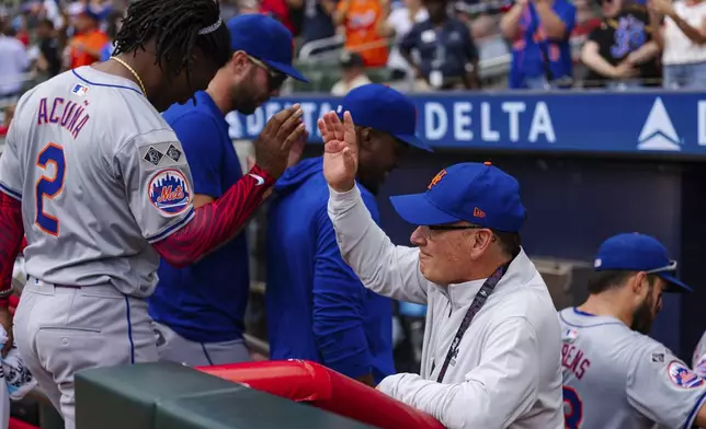 New York Mets owner, Steve Cohen, right, high fives Luisangel Acuña in the dugout after winning the game in the ninth inning of a baseball game against the Atlanta Braves, Monday, Sept. 30, 2024, in Atlanta. (AP Photo/Jason Allen)