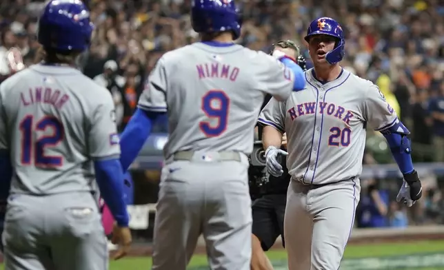 New York Mets' Pete Alonso celebrates his three-run home run with Brandon Nimmo (9) and Francisco Lindor (12) during the ninth inning of Game 3 of a National League wild card baseball game against the Milwaukee Brewers Thursday, Oct. 3, 2024, in Milwaukee. (AP Photo/Morry Gash)