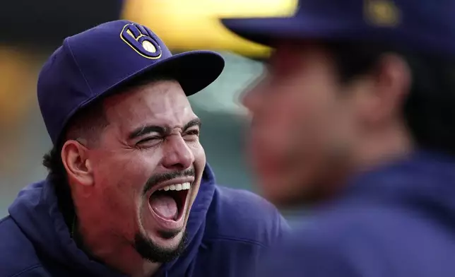 Milwaukee Brewers' Willy Adames, left, laughs from the dugout during the eighth inning of a baseball game against the New York Mets, Sunday, Sept. 29, 2024, in Milwaukee. (AP Photo/Aaron Gash)