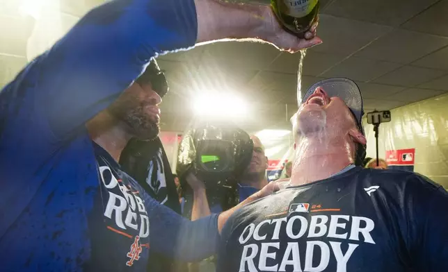 New York Mets' J.D. Martinez and Pete Alonso celebrate after winning Game 3 of a National League wild card baseball game against the Milwaukee Brewers Thursday, Oct. 3, 2024, in Milwaukee. The Mets won 4-2. (AP Photo/Morry Gash)