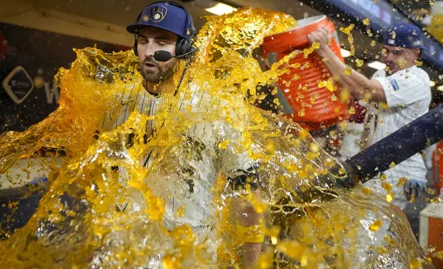 Milwaukee Brewers' Garrett Mitchell is douced by Willy Adames after Game 2 of a National League wild card baseball game against the New York Mets Wednesday, Oct. 2, 2024, in Milwaukee. The Brewers won 5-3 to tie the series 1-1. (AP Photo/Morry Gash)