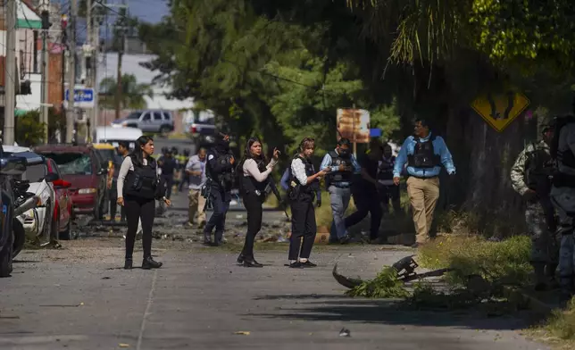 Security agents and experts on the scene where a car bomb exploded near a police station, in Acambaro, Guanajuato state, Mexico, Thursday, Oct. 24, 2024. (AP Photo/Armando Solis)