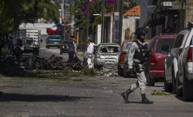 Security agents and experts on the scene where a car bomb exploded near a police station, in Acambaro, Guanajuato state, Mexico, Thursday, Oct. 24, 2024. (AP Photo/Armando Solis)