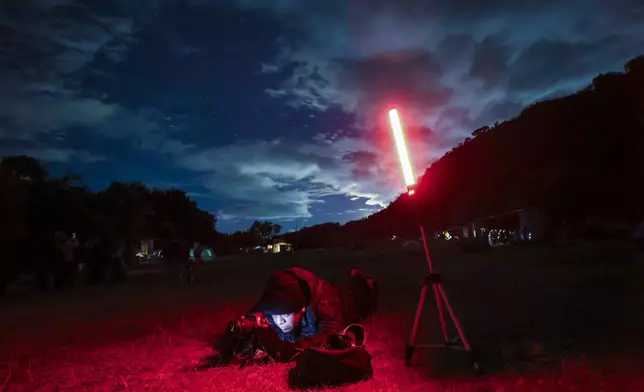 Photographer David Garcia adjusts his camera as he attends a stargazing and comet-watching gathering at Joya-La Barreta ecological park in Queretaro, Mexico, Saturday, Oct. 19, 2024. (AP Photo/Ginnette Riquelme)