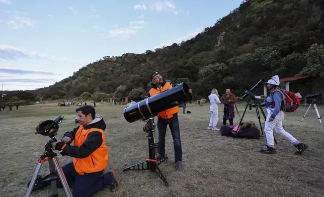 Frank Medina, left, and Juan Carlos Hernandez, center, arrange telescopes before attending a stargazing and comet-watching gathering at Joya-La Barreta ecological park in Queretaro, Mexico, Saturday, Oct. 19, 2024. (AP Photo/Ginnette Riquelme)