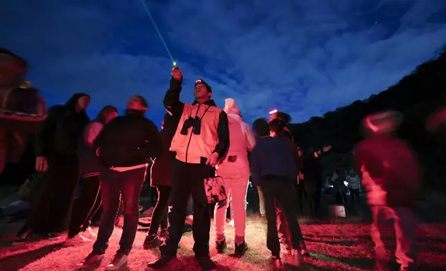 Ricardo Soriano, with a green laser, points at the sky during a stargazing and comet-watching gathering at Joya-La Barreta ecological park in Queretaro, Mexico, Saturday, Oct. 19, 2024. (AP Photo/Ginnette Riquelme)