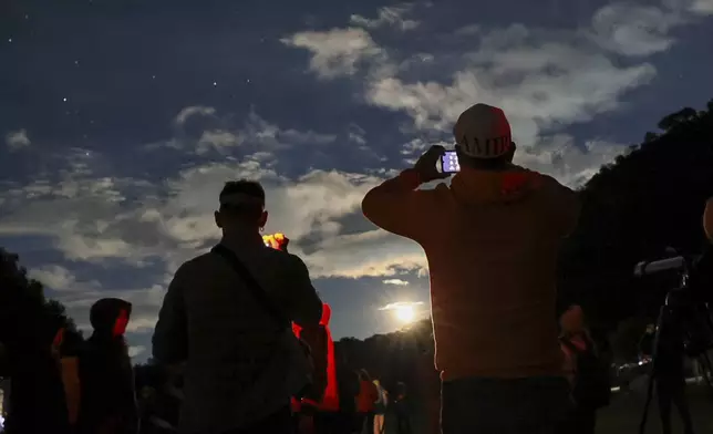 People take photos of the sky at a stargazing and comet-watching gathering at Joya-La Barreta Ecological Park in Queretaro, Mexico, Saturday, Oct. 19, 2024. (AP Photo/Ginnette Riquelme)