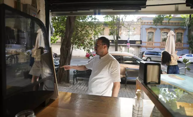 Manu Tovar opens the doors of his bakery to sell pan de muerto, or "bread of the dead," traditional for Mexico's Day of the Dead, in the San Rafael neighborhood of Mexico City, Thursday, Oct. 17, 2024. (AP Photo/Fernando Llano)