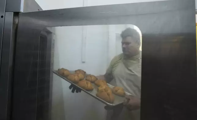 Victor Silverio prepares pan de muerto, or "bread of the dead," traditional for Mexico's Day of the Dead, at a bakery in the San Rafael neighborhood of Mexico City, Thursday, Oct. 17, 2024. (AP Photo/Fernando Llano)