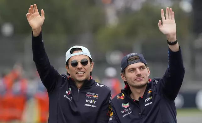 Red Bull driver Max Verstappen of the Netherlands, right, and teammate Sergio Perez of Mexico greet spectators before the Formula One Mexico Grand Prix auto race at the Hermanos Rodriguez racetrack in Mexico City, Sunday, Oct. 27, 2024. (AP Photo/Moises Castillo)