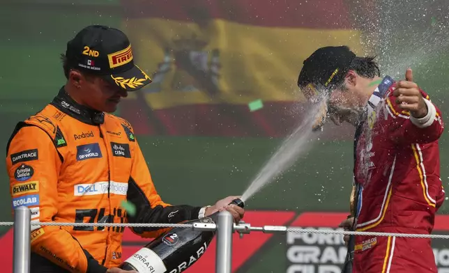 Ferrari driver Carlos Sainz of Spain gets champagne sprayed in his face by second placed McLaren driver Lando Norris of Britain after winning the Formula One Mexico Grand Prix auto race at the Hermanos Rodriguez racetrack in Mexico City, Sunday, Oct. 27, 2024. (AP Photo/Fernando Llano)