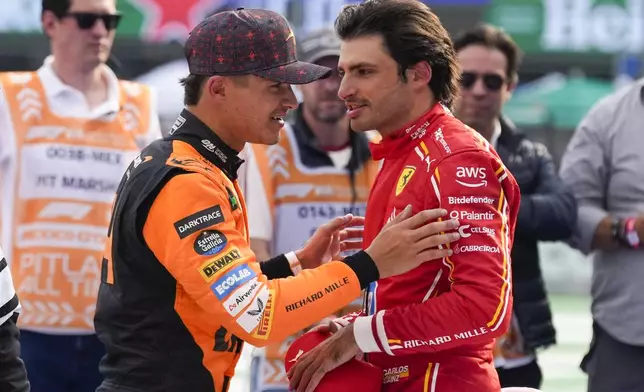 Formula One Mexico Grand Prix auto race winner Ferrari driver Carlos Sainz of Spain, right, talks with the second-place finisher, McLaren driver Lando Norris of the United Kingdom, at the Hermanos Rodriguez racetrack in Mexico City, Sunday, Oct. 27, 2024. (AP Photo/Moises Castillo)