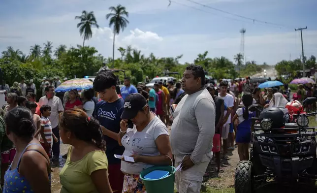 Residents line up to receive food delivered by the Army after Hurricane John passed through Coyuca de Benitez, Guerrero Mexico, Monday, Sept. 30, 2024. (AP Photo/Felix Marquez)