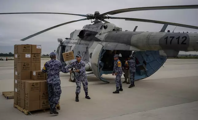 Mexican Air Force officers pack food for victims of Hurricane John, which hit the state of Guerrero, in Mexico City, Monday, Sept. 30, 2024. (AP Photo/Felix Marquez)