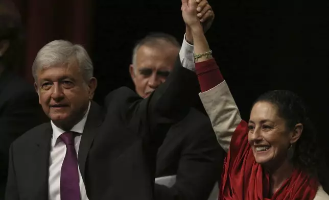 FILE - Presidential hopeful Andres Manuel Lopez Obrador, left, and Claudia Sheinbaum, coordinator of the Morena political party, hold hands at an event at the National Auditorium in Mexico City, Nov. 20, 2017. (AP Photo/Marco Ugarte, File)