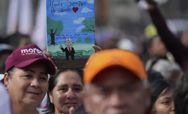 A supporter of new President Claudia Sheinbaum holds a painting of outgoing President Andrés Manuel López Obrador that reads in Spanish "Farewell, President" during a rally in the Zócalo, Mexico City's main square, Tuesday, Oct. 1, 2024. (AP Photo/Eduardo Verdugo)