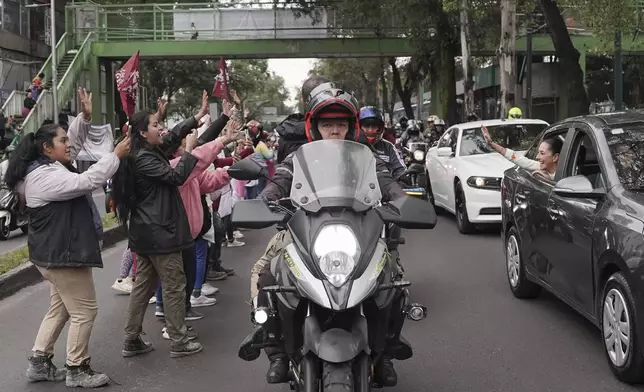 Claudia Sheinbaum waves to supporters from the vehicle taking her to Congress to be sworn in as president in Mexico City, Tuesday, Oct. 1, 2024. (AP Photo/Aurea Del Rosario)