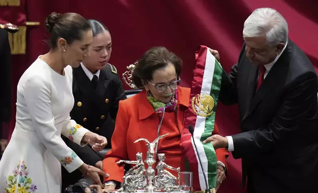 Outgoing President Andres Manuel Lopez Obrador hands the presidential sash to Ifigenia Martinez, president of the Chamber of Deputies, during the swearing-in ceremony of Claudia Sheinbaum, left, at Congress in Mexico City, Tuesday, Oct. 1, 2024. (AP Photo/Eduardo Verdugo)